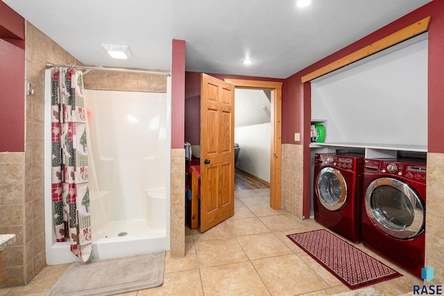 laundry room featuring laundry area, light tile patterned flooring, independent washer and dryer, and tile walls