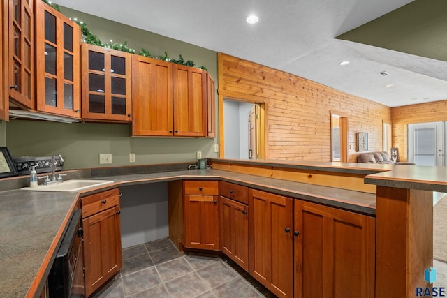 kitchen featuring black dishwasher, dark countertops, glass insert cabinets, a peninsula, and a sink