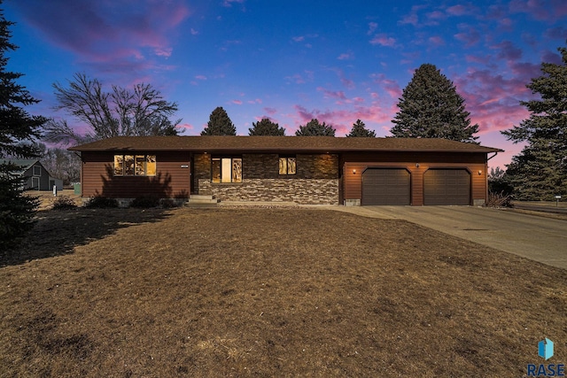 ranch-style home featuring a garage and driveway