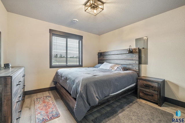 bedroom featuring baseboards and light wood finished floors