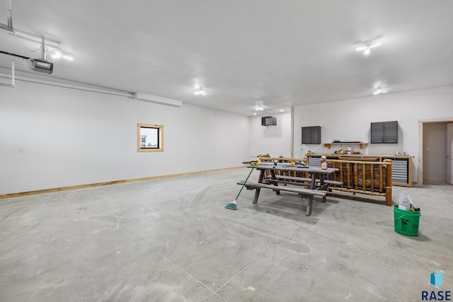 garage featuring baseboards, a workshop area, and a garage door opener