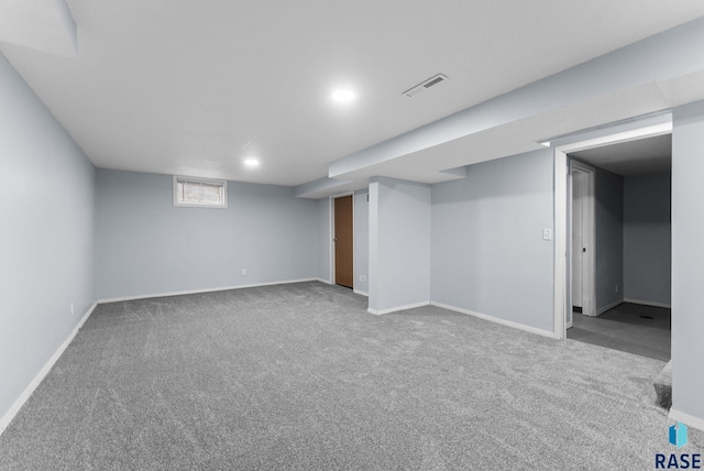 below grade area featuring carpet floors, visible vents, and baseboards