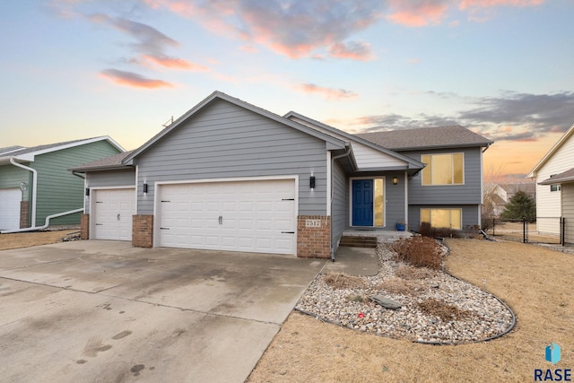 view of front of home featuring a garage, driveway, brick siding, and fence