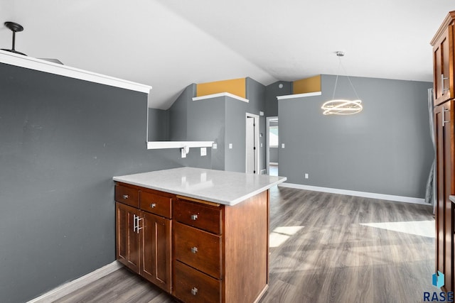 kitchen featuring lofted ceiling, a notable chandelier, wood finished floors, baseboards, and light countertops