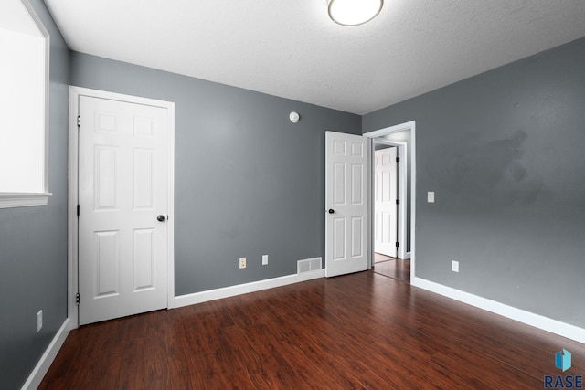 empty room featuring visible vents, baseboards, and wood finished floors