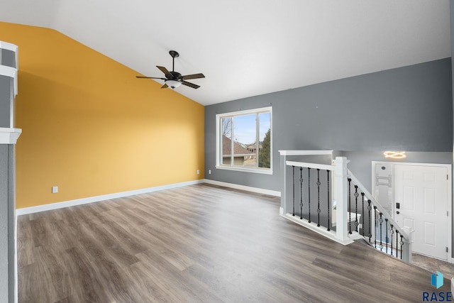 unfurnished living room with lofted ceiling, baseboards, and wood finished floors