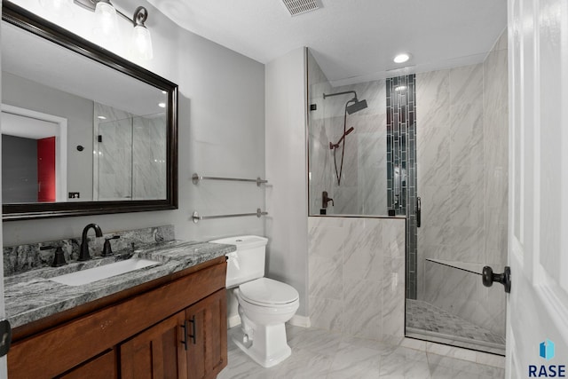 bathroom featuring a marble finish shower, visible vents, toilet, vanity, and baseboards