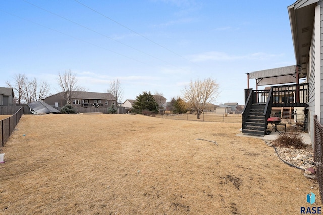 view of yard featuring a fenced backyard and stairs