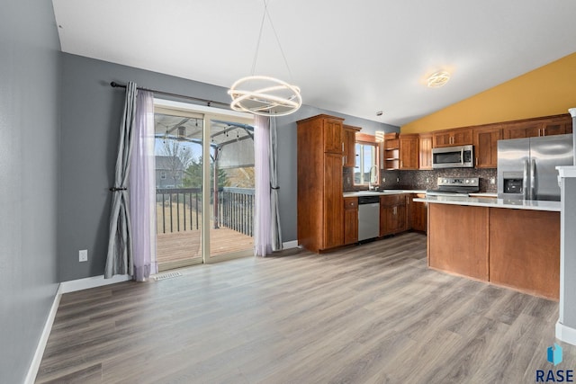 kitchen featuring open shelves, light countertops, decorative backsplash, appliances with stainless steel finishes, and light wood-style floors