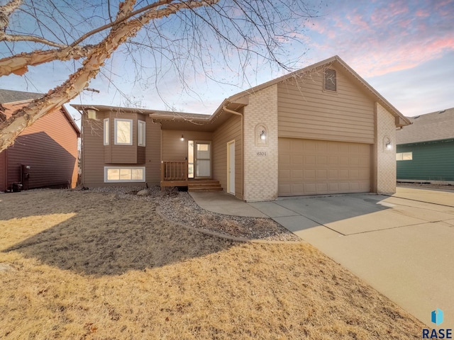 view of front of house with brick siding, driveway, and an attached garage