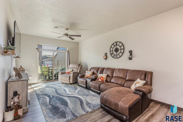 living area with ceiling fan, baseboards, and wood finished floors