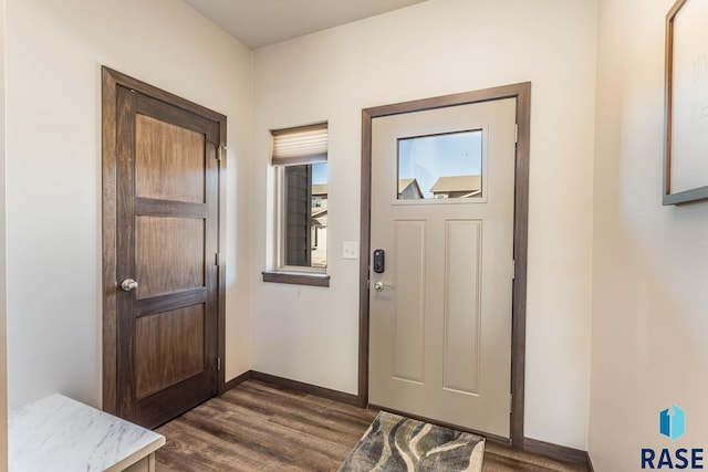 foyer featuring dark wood-type flooring and baseboards