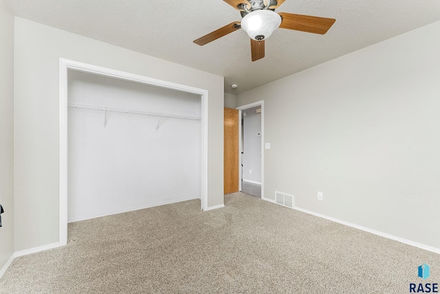 unfurnished bedroom featuring carpet floors, a textured ceiling, visible vents, and a closet