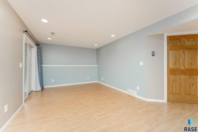 unfurnished room featuring recessed lighting, visible vents, light wood-style flooring, and baseboards