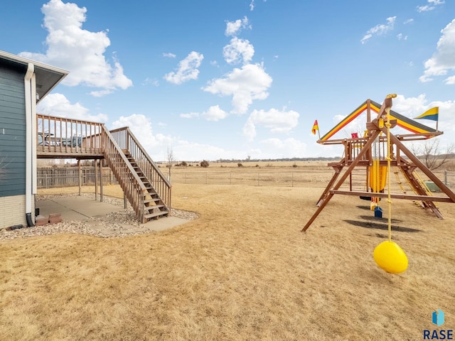 view of jungle gym with a deck, stairway, and fence