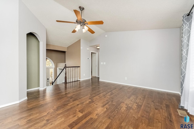 spare room with wood finished floors, a ceiling fan, visible vents, vaulted ceiling, and baseboards