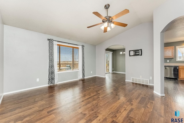 unfurnished room featuring arched walkways, lofted ceiling, dark wood-style flooring, visible vents, and baseboards