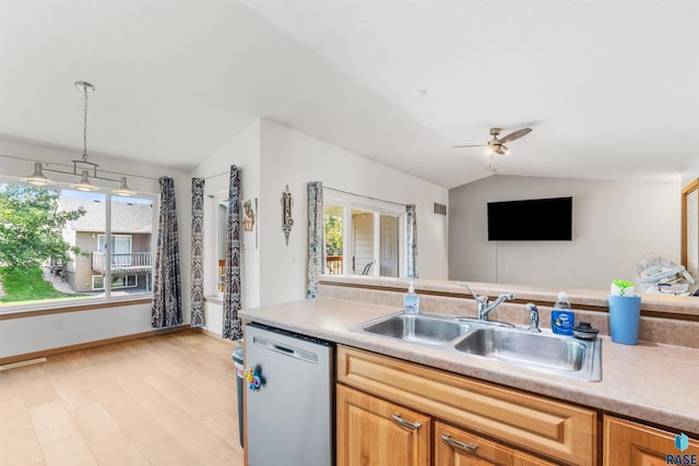 kitchen with a sink, a ceiling fan, vaulted ceiling, light countertops, and stainless steel dishwasher