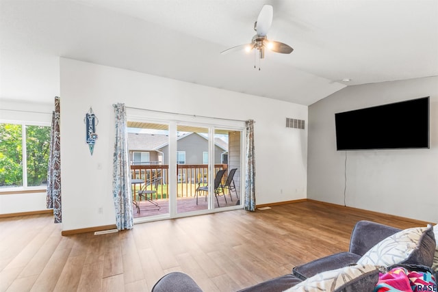 unfurnished living room with baseboards, visible vents, a ceiling fan, wood finished floors, and vaulted ceiling