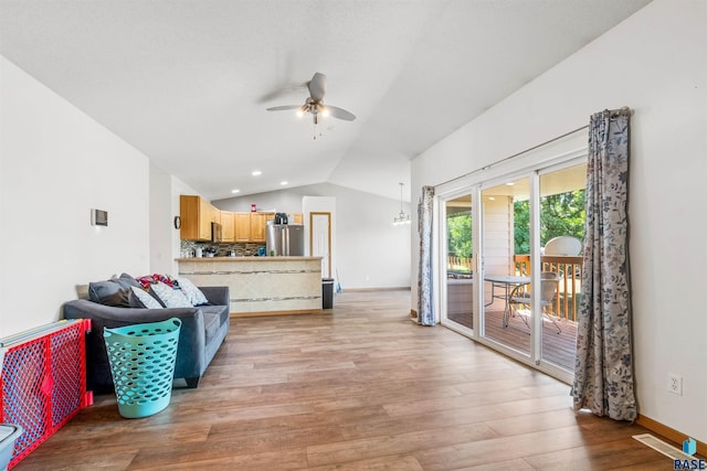 living room with baseboards, visible vents, a ceiling fan, lofted ceiling, and light wood-type flooring