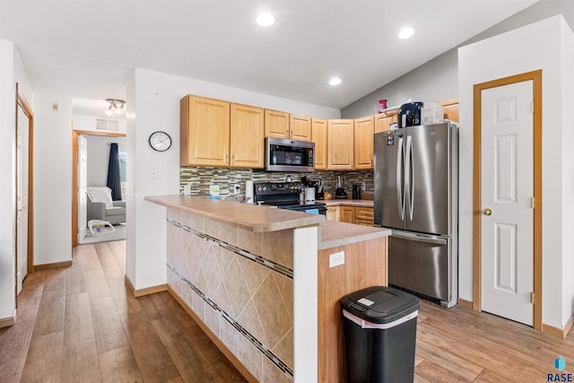 kitchen with light brown cabinetry, appliances with stainless steel finishes, light wood-style flooring, and tasteful backsplash