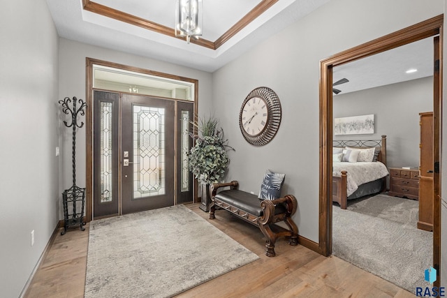 8501 E Torchwood Pl, Sioux Falls, SD 57110 - entrance foyer featuring light wood-type flooring, baseboards, a tray ceiling, and crown molding