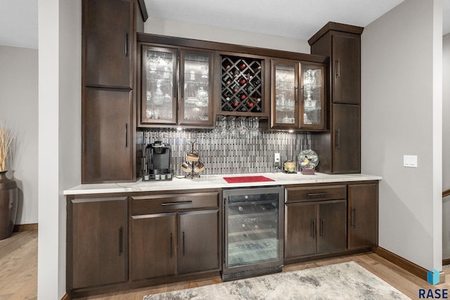 8501 E Torchwood Pl, Sioux Falls, SD 57110 - bar with beverage cooler, a dry bar, light wood-type flooring, and backsplash