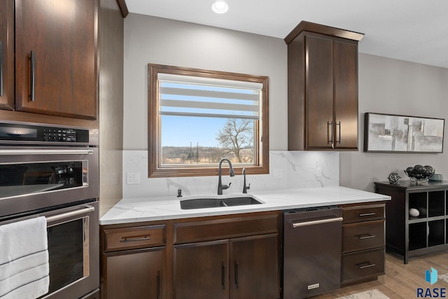 8501 E Torchwood Pl, Sioux Falls, SD 57110 - kitchen with decorative backsplash, dishwasher, dark brown cabinets, double oven, and a sink