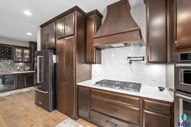 8501 E Torchwood Pl, Sioux Falls, SD 57110 - kitchen with beverage cooler, premium range hood, appliances with stainless steel finishes, and dark brown cabinetry