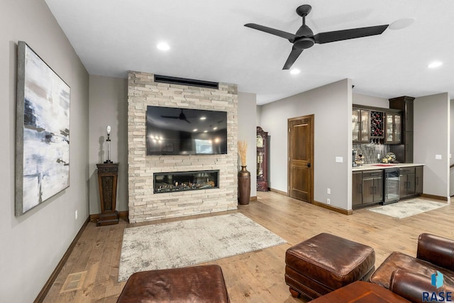 8501 E Torchwood Pl, Sioux Falls, SD 57110 - living room featuring a dry bar, visible vents, light wood-style flooring, a stone fireplace, and beverage cooler