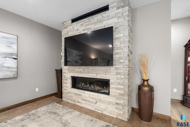 8501 E Torchwood Pl, Sioux Falls, SD 57110 - living area featuring a fireplace, wood finished floors, and baseboards