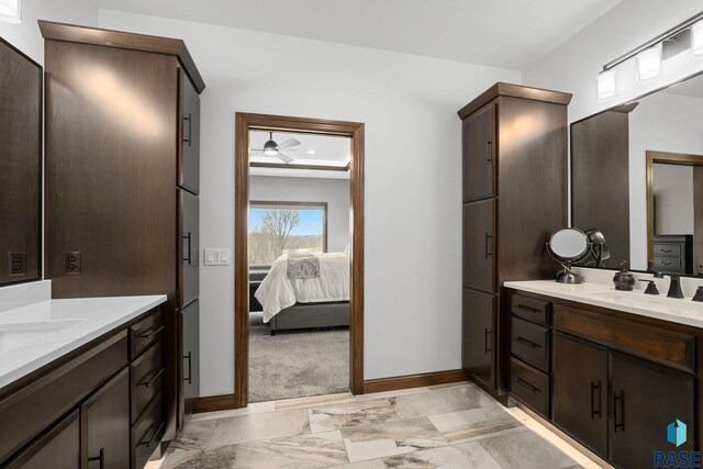 8501 E Torchwood Pl, Sioux Falls, SD 57110 - full bath featuring connected bathroom, two vanities, a sink, baseboards, and marble finish floor
