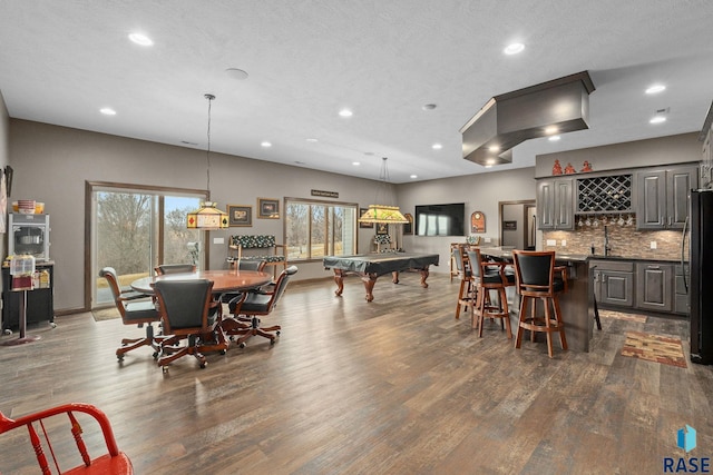 8501 E Torchwood Pl, Sioux Falls, SD 57110 - dining area with baseboards, dark wood-type flooring, a textured ceiling, indoor wet bar, and recessed lighting