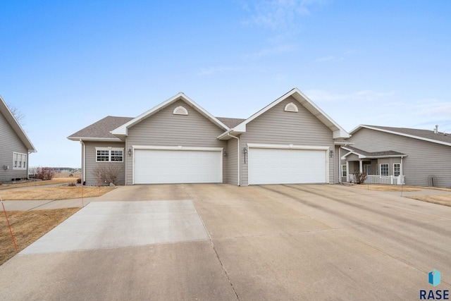 ranch-style house featuring a shingled roof, driveway, and an attached garage