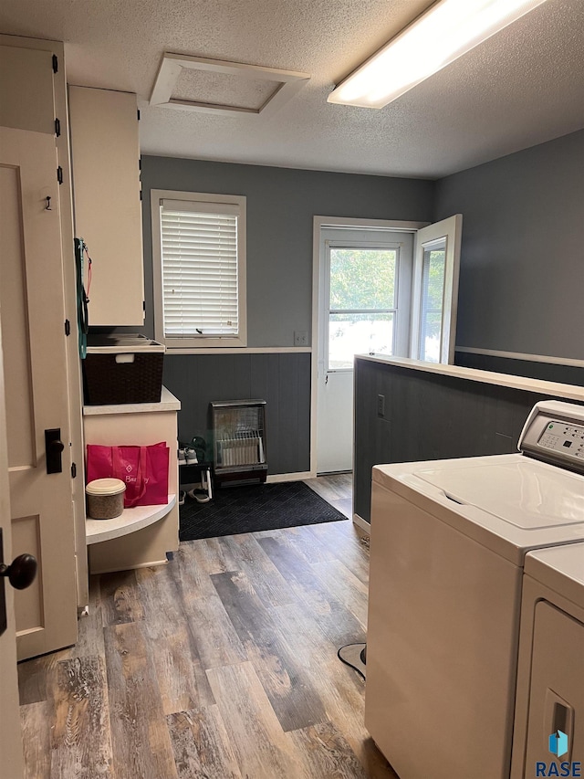 laundry area with attic access, wainscoting, a textured ceiling, separate washer and dryer, and wood finished floors