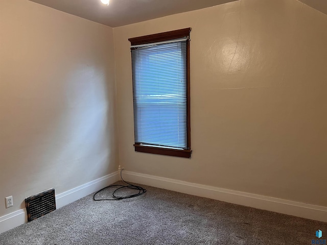 carpeted spare room with visible vents and baseboards