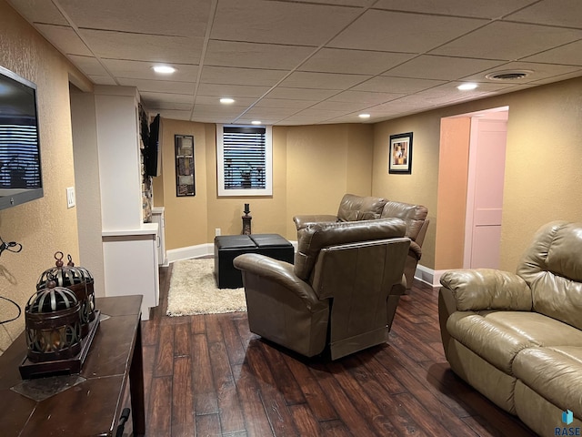 living room with a paneled ceiling, dark wood finished floors, visible vents, and baseboards