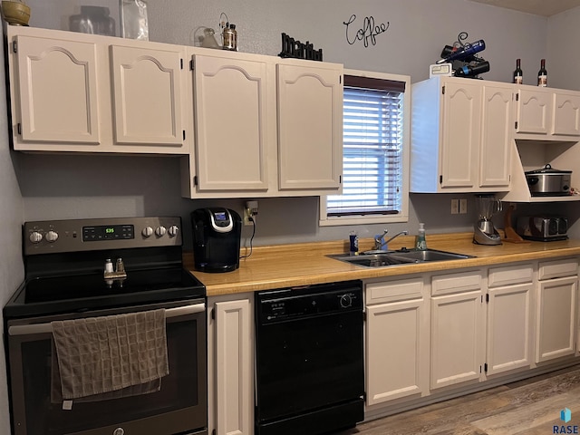 kitchen featuring white cabinets, dishwasher, stainless steel electric range, light countertops, and a sink