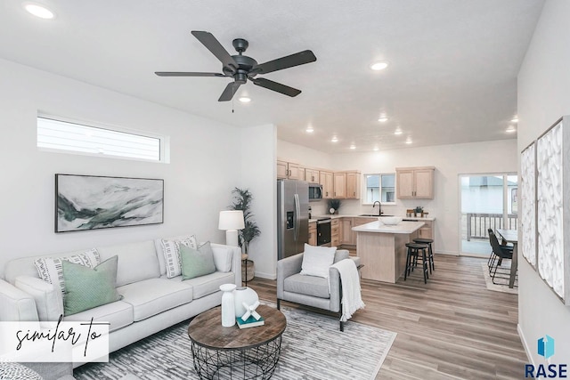 living room with baseboards, light wood-type flooring, and recessed lighting