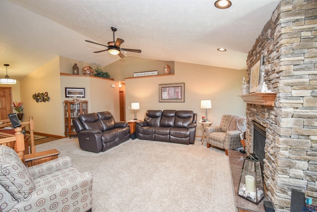 living room with baseboards, a ceiling fan, carpet, vaulted ceiling, and a stone fireplace