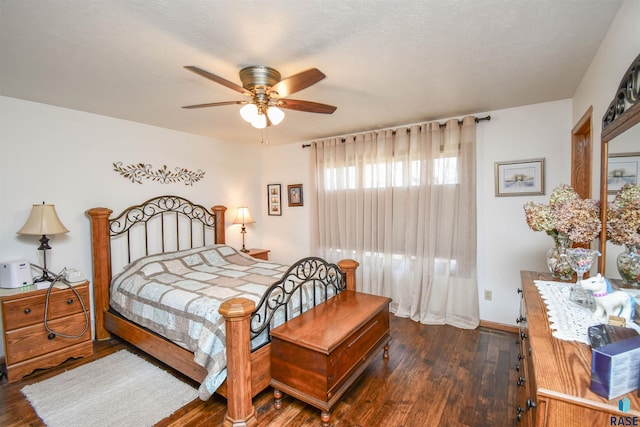 bedroom with a textured ceiling, baseboards, and dark wood-style flooring