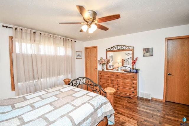 bedroom featuring a ceiling fan, baseboards, visible vents, and dark wood-type flooring