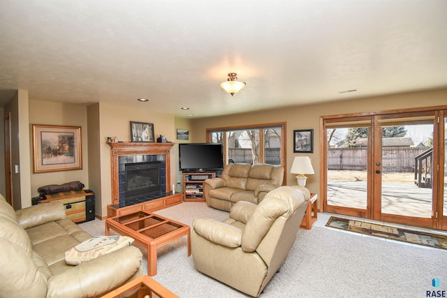 living room with carpet floors, recessed lighting, visible vents, and a tiled fireplace