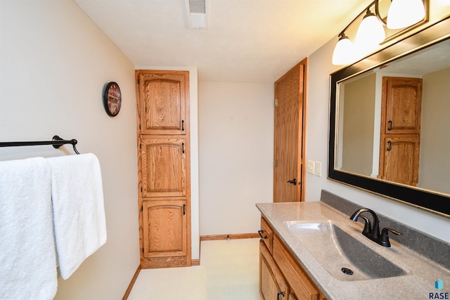 bathroom with baseboards, visible vents, and vanity