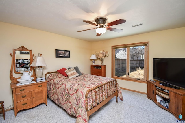 bedroom with light carpet, baseboards, visible vents, and a ceiling fan