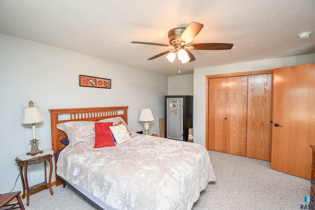 bedroom with a closet, light colored carpet, and ceiling fan