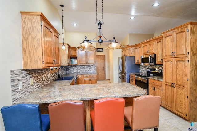 kitchen featuring light tile patterned floors, a peninsula, a sink, vaulted ceiling, and appliances with stainless steel finishes