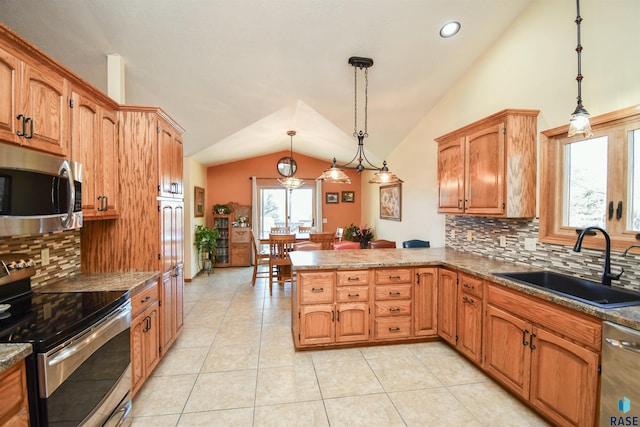 kitchen featuring appliances with stainless steel finishes, a peninsula, vaulted ceiling, a sink, and light tile patterned flooring