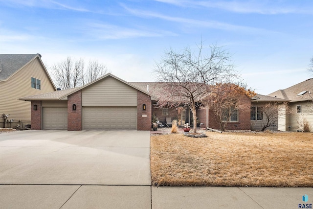 view of front facade featuring a garage, driveway, and brick siding