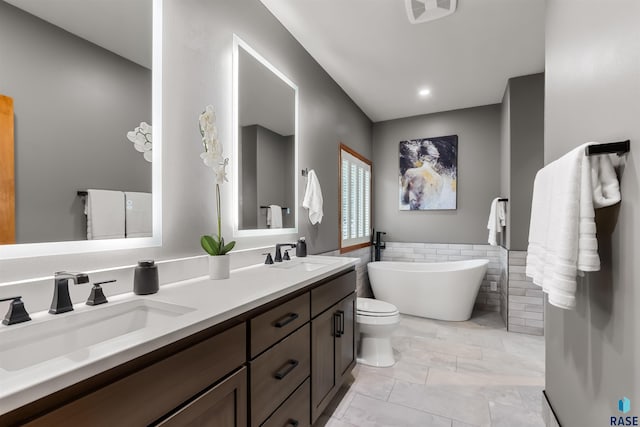 bathroom featuring a freestanding tub, visible vents, a sink, and tile walls